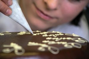 Konditorin Inge beschriftet Sachertorte